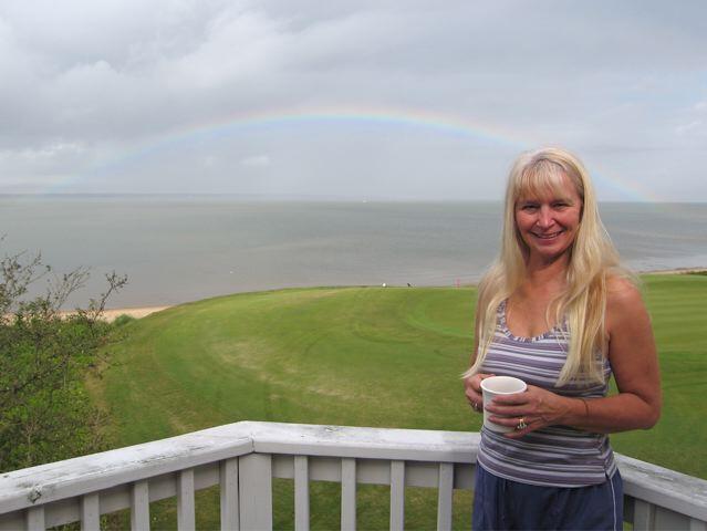 Peggy admires rainbow from our deck as storm winds diminish