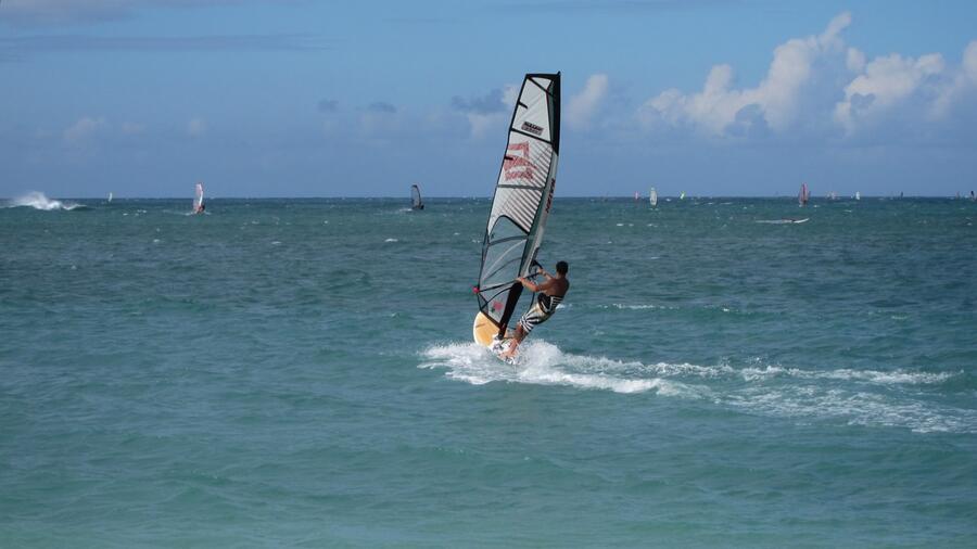 Windsurfing scene, wave on left breaking on reef